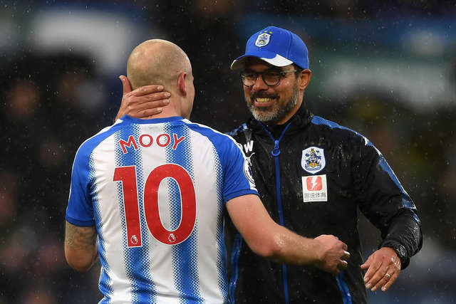 Aaron Mooy and David Wagner embrace on the pitch.